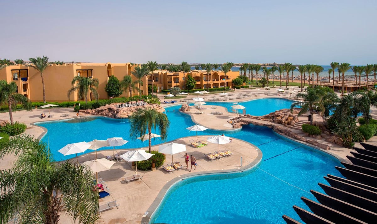 Stella Beach Resort & Spa Makadi Bay pool area with connected pools and palm trees.