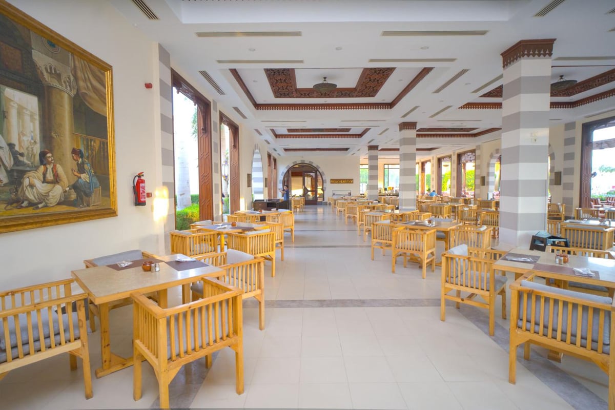 Stella Beach Resort & Spa Makadi Bay dining room with wooden tables and an ornate ceiling.