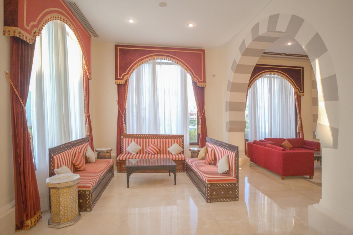 Stella Beach Resort & Spa Makadi Bay lounge with striped sofas and arched windows.