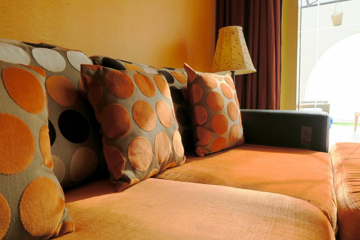 Retac Qunay Dahab Resort & Spa sofa seating with orange upholstery and patterned cushions.