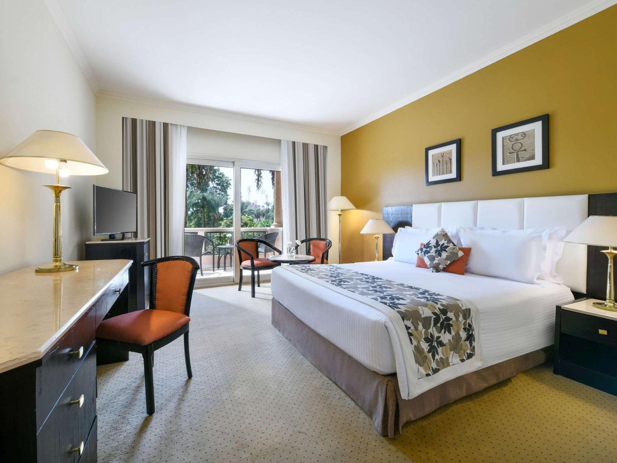Pavillon Winter Luxor guest room with a large bed and glass doors.
