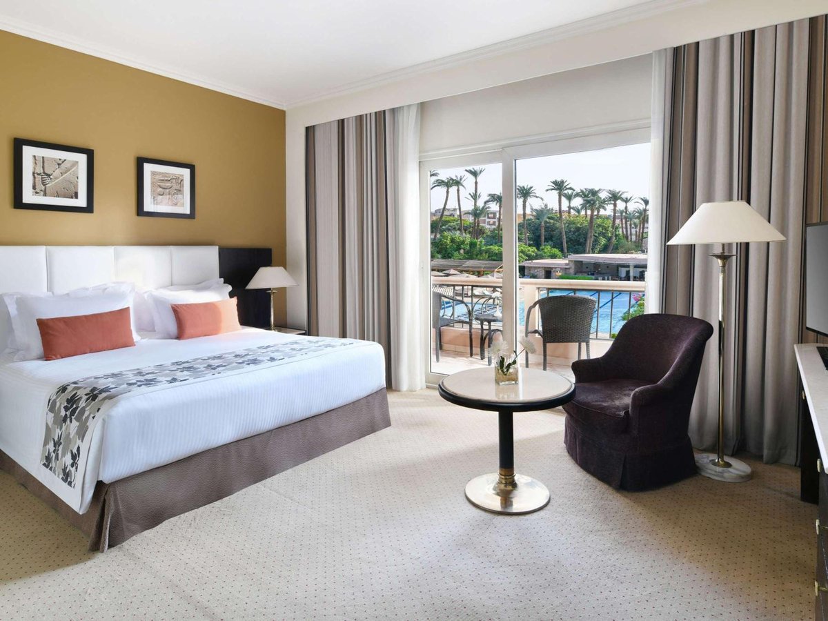 Pavillon Winter Luxor bedroom with a large bed and glass doors to a terrace.