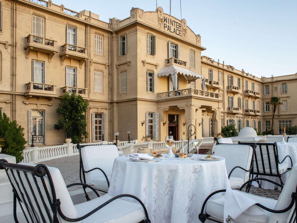 Pavillon Winter Luxor outdoor dining terrace with a round table and cream-coloured facade.