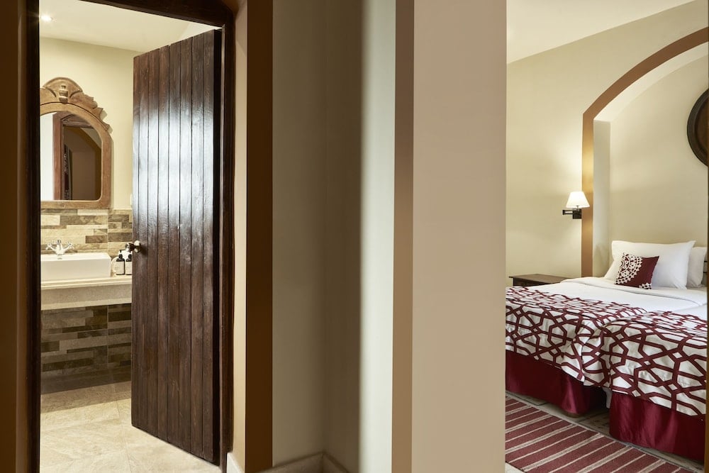 Dawar El Omda Hotel El Gouna (Adults Only) guest room with twin beds and an arched wall.