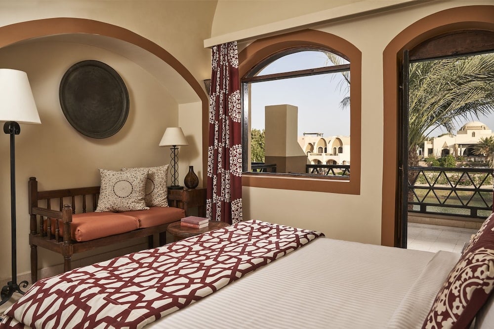 Dawar El Omda Hotel El Gouna (Adults Only) guest room with a patterned bed and arched windows.