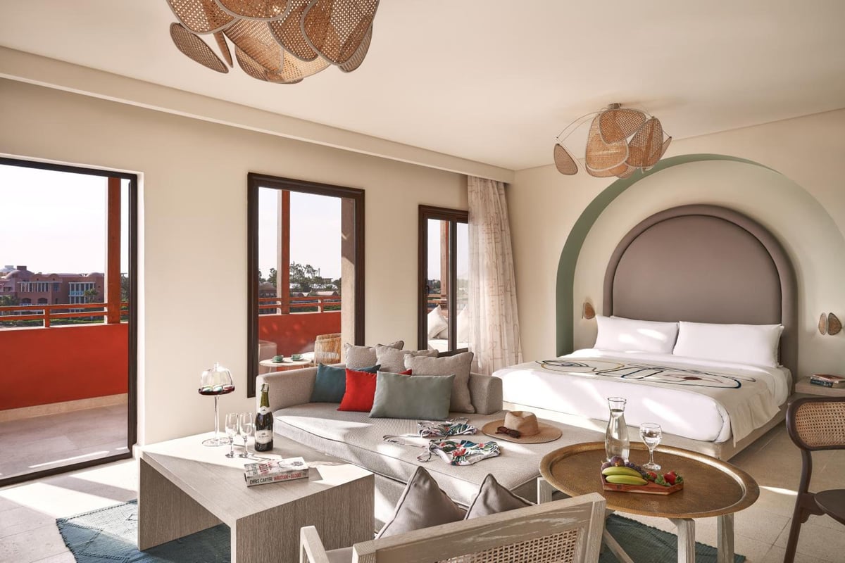 Three Corners Ocean View El Gouna (Adults Only) guest bedroom with an arched headboard and sitting area.