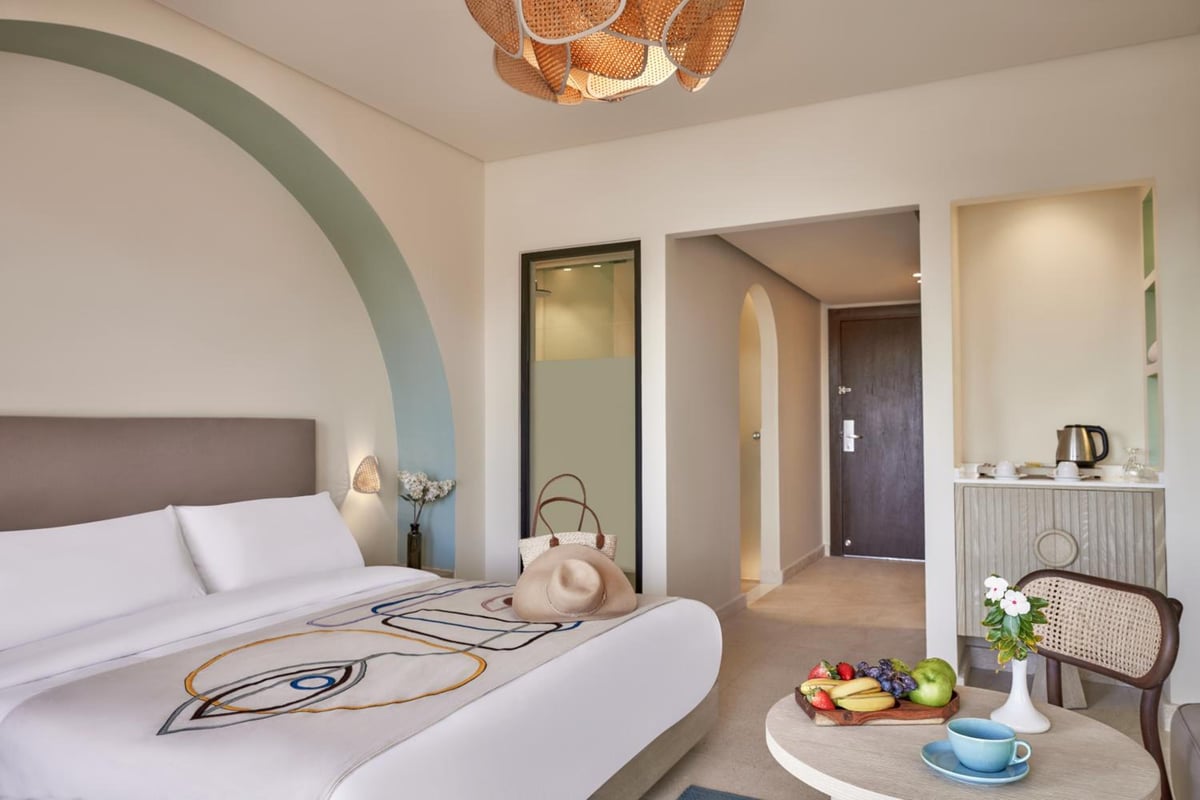 Three Corners Ocean View El Gouna (Adults Only) bedroom with a white bed and arched wall.