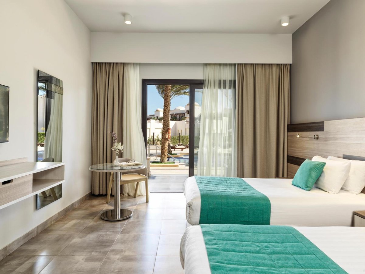 Ancient Sands Golf Resort twin bedroom with two beds and sliding glass doors.