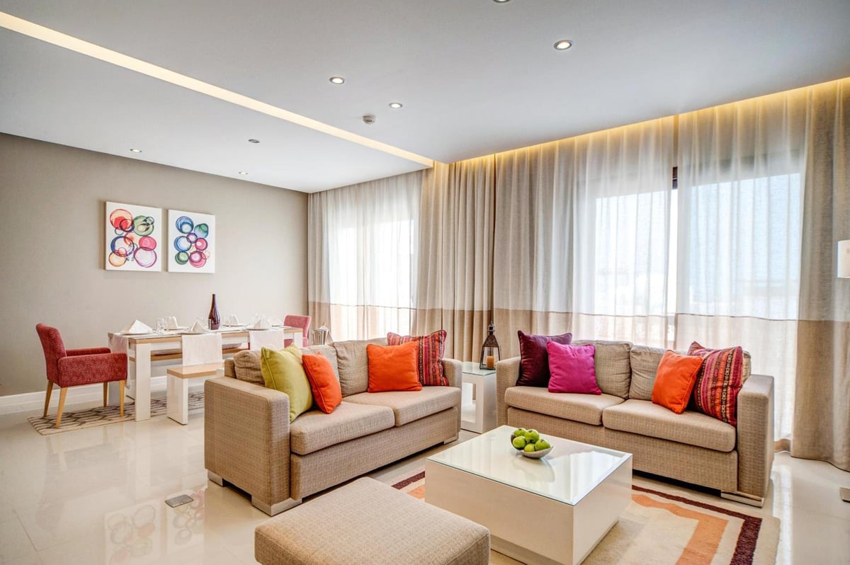 Ancient Sands Golf Resort living room with two sofas and large windows.