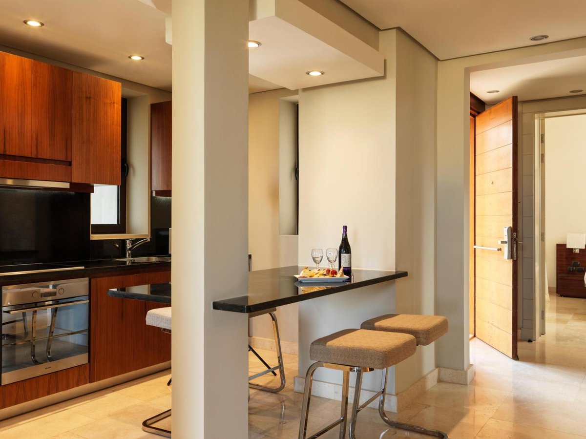 Ancient Sands Golf Resort kitchen with a breakfast bar and two stools.