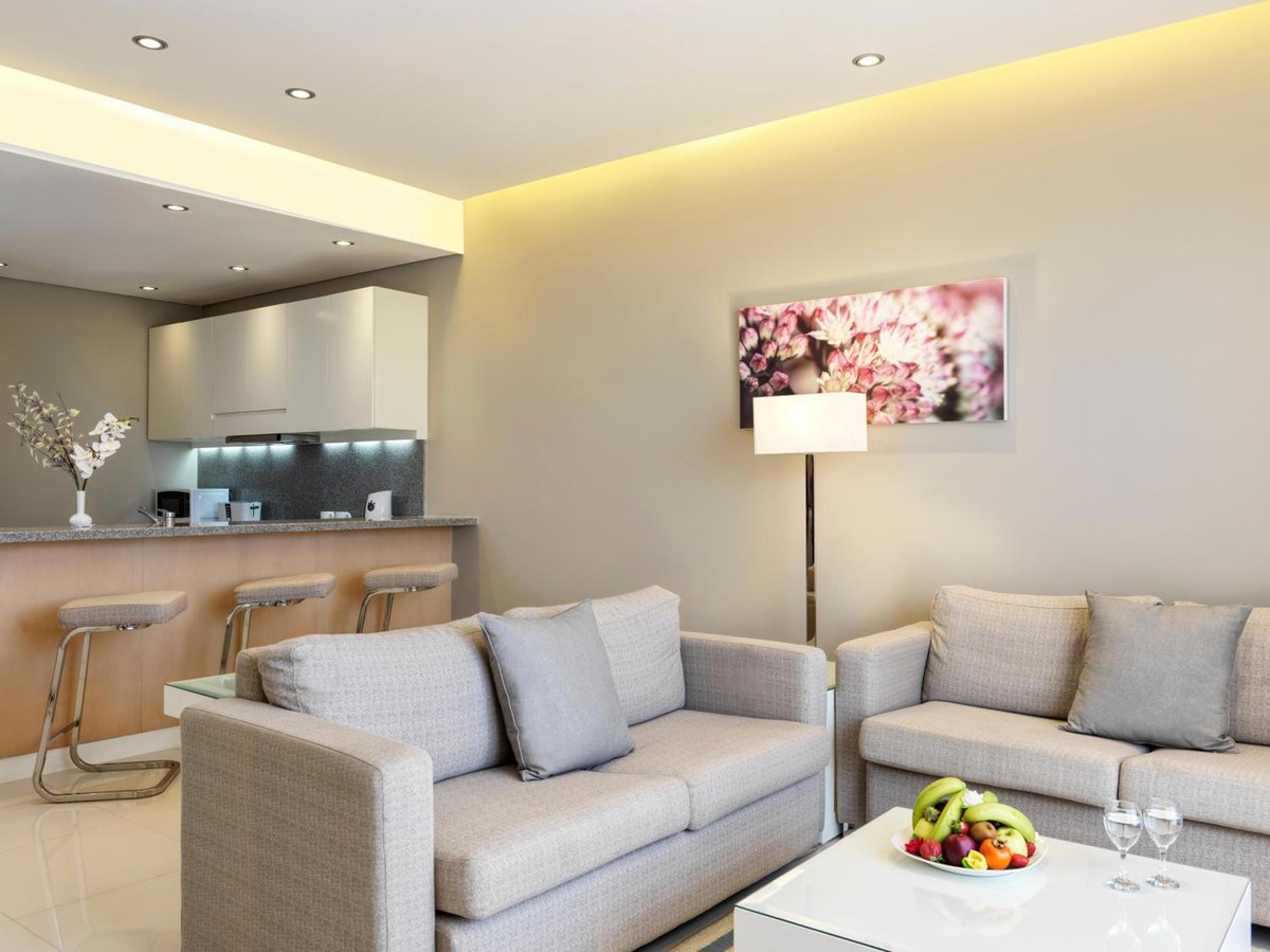 Ancient Sands Golf Resort lounge with sofas and a kitchenette.