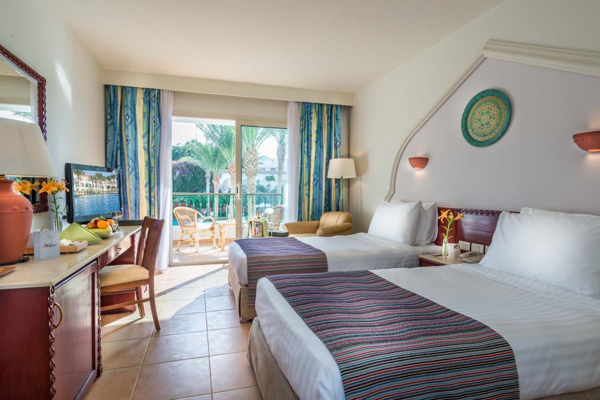 Baron Palms Resort (Adults Only) guest room with twin beds and glass doors to a balcony.