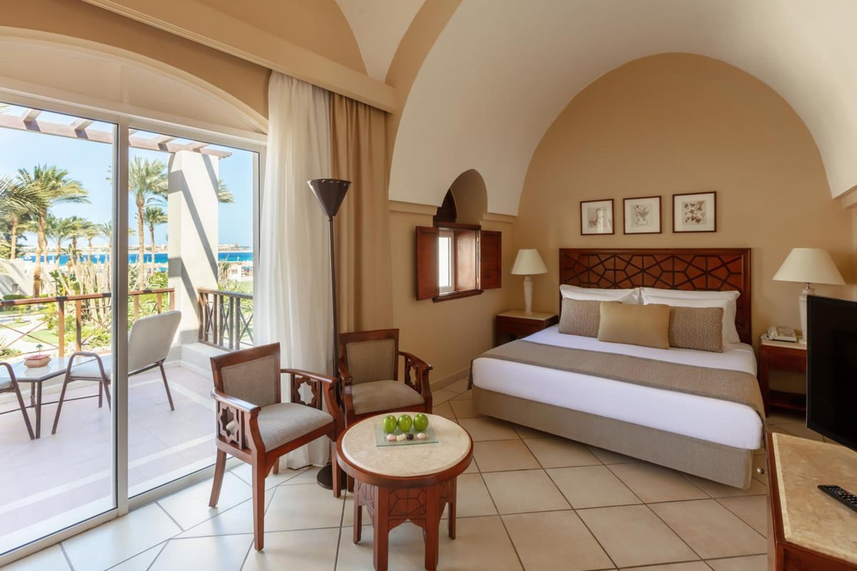 Iberotel Makadi Beach bedroom with a large bed and sliding doors to a balcony.
