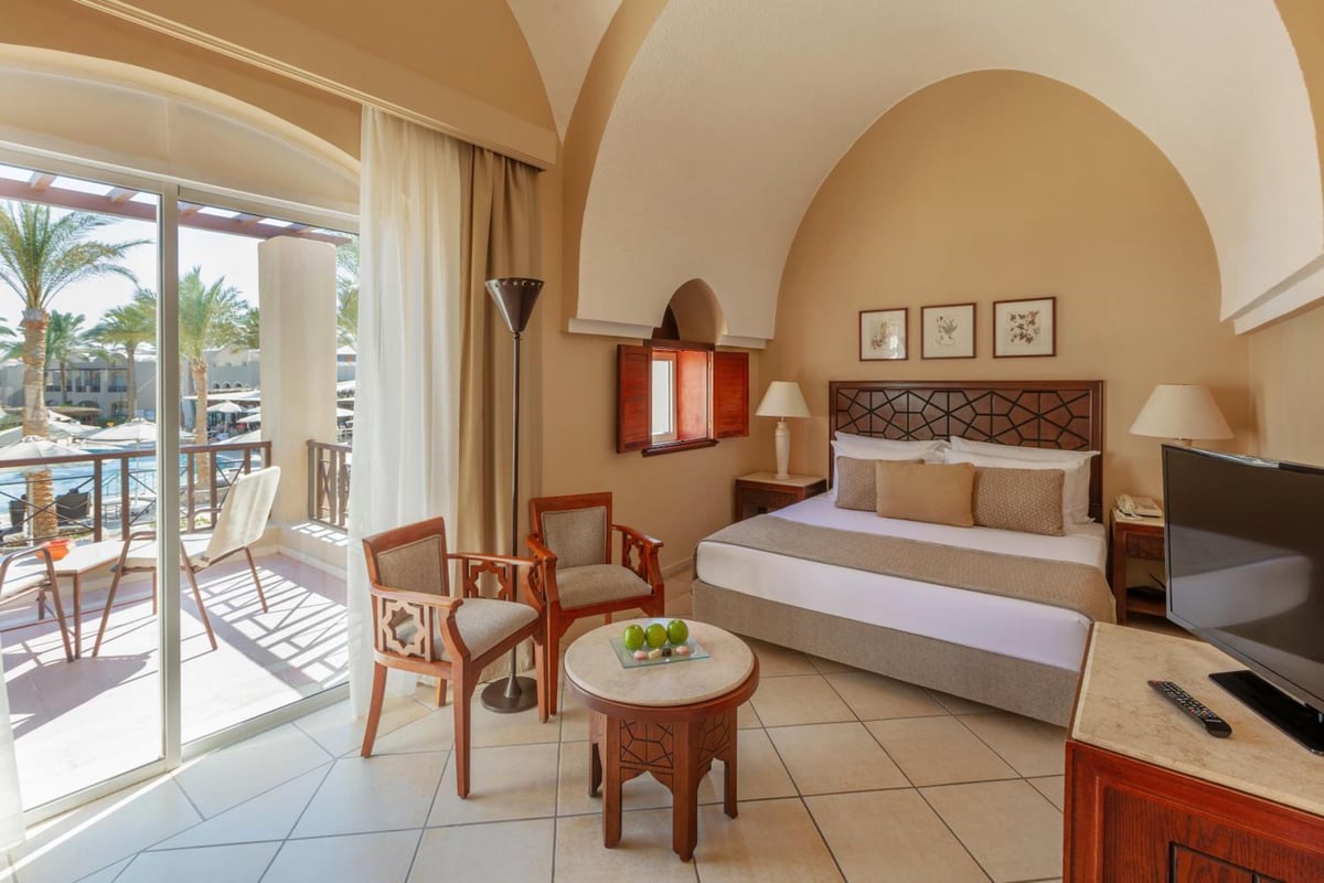 Iberotel Makadi Beach guest room with an arched ceiling and sliding glass doors.