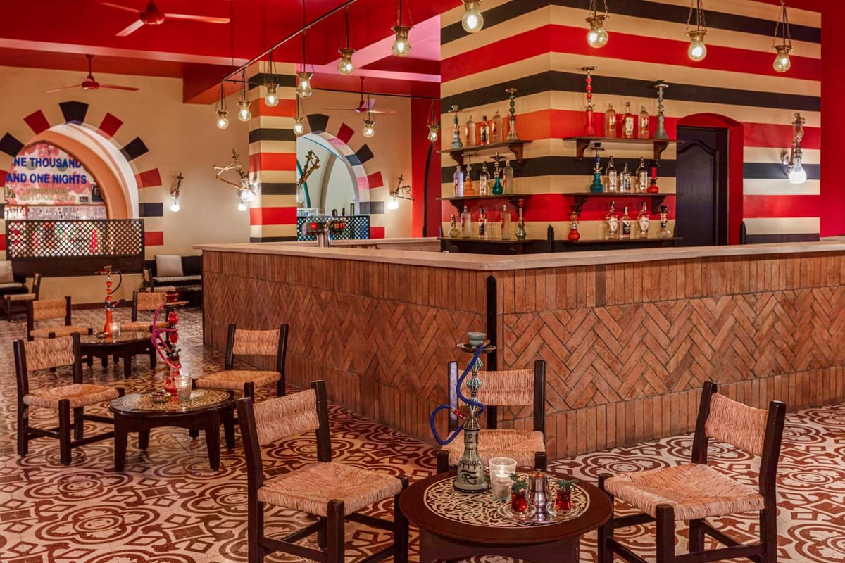 Iberotel Makadi Beach lounge bar with a wood-fronted counter and striped walls.