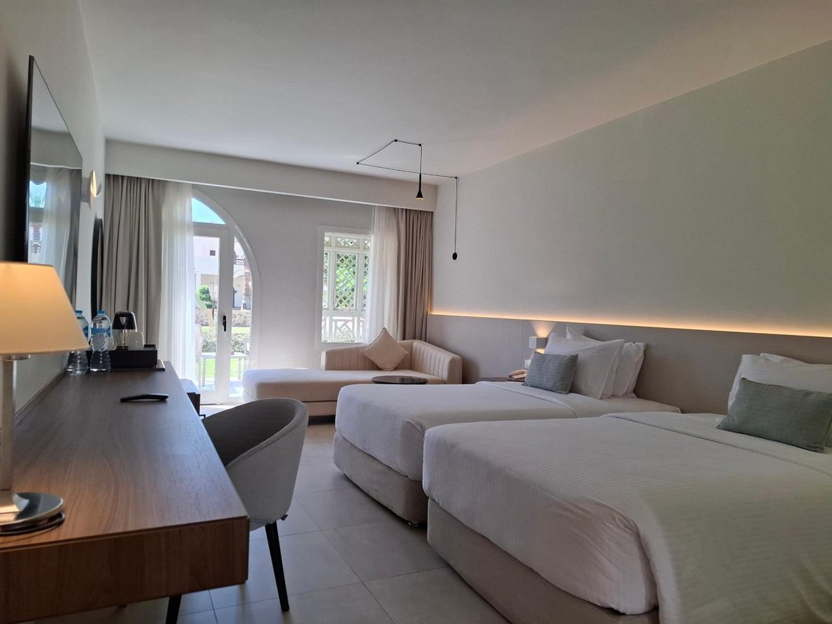 Reef Oasis Beach Aqua Park Resort bedroom with twin beds and balcony doors.