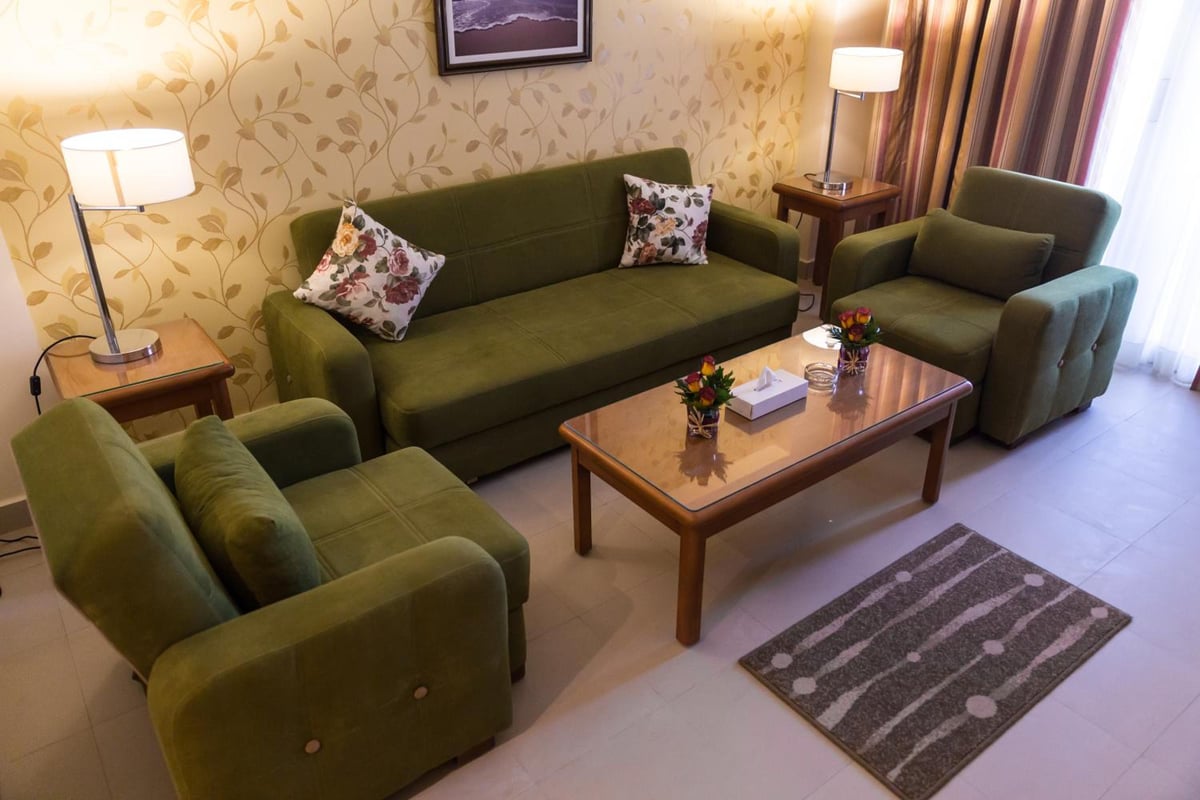 The Grand Plaza Hotel Smouha lounge with green sofas and a coffee table.
