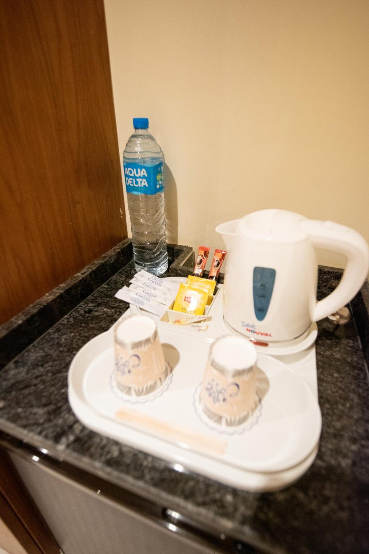 The Grand Plaza Hotel Smouha tea and coffee station with an electric kettle and bottled water.