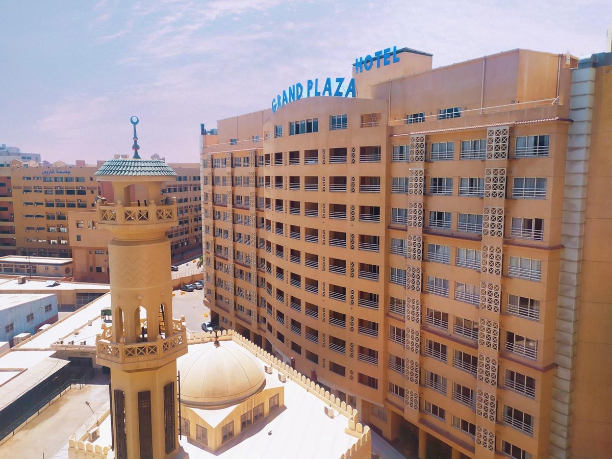 The Grand Plaza Hotel Smouha exterior with a tan facade and rooftop sign.
