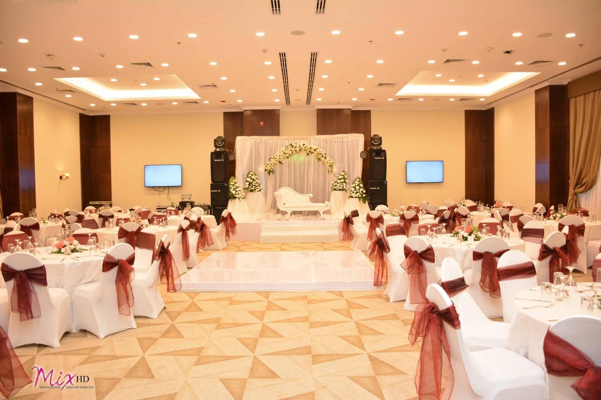 The Grand Plaza Hotel Smouha ballroom with a floral stage arch and banquet tables.