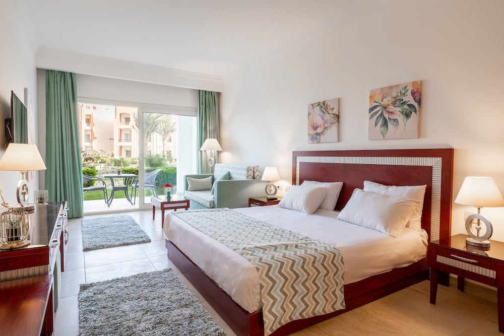 Oyster Bay Beach Suites bedroom with a large bed and sliding glass doors.