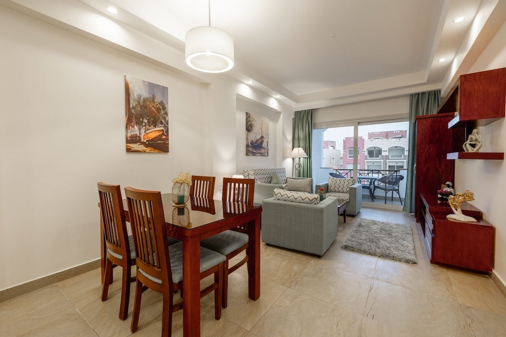 Oyster Bay Beach Suites living-dining area with a dining table and gray sofas.