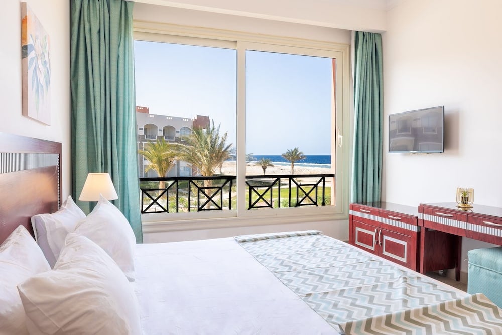 Oyster Bay Beach Suites bedroom with a sea view and large windows.
