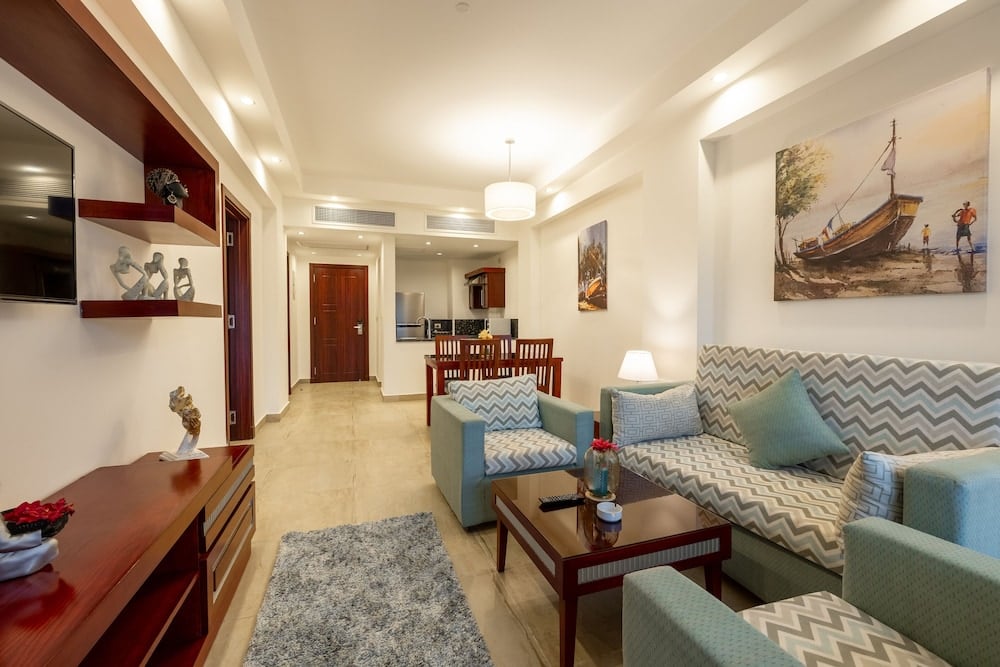 Oyster Bay Beach Suites living room with patterned seating and dining area.