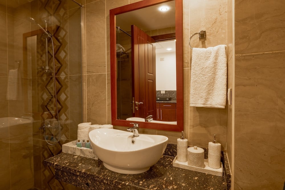 Oyster Bay Beach Suites bathroom with a vessel sink and glass shower enclosure.