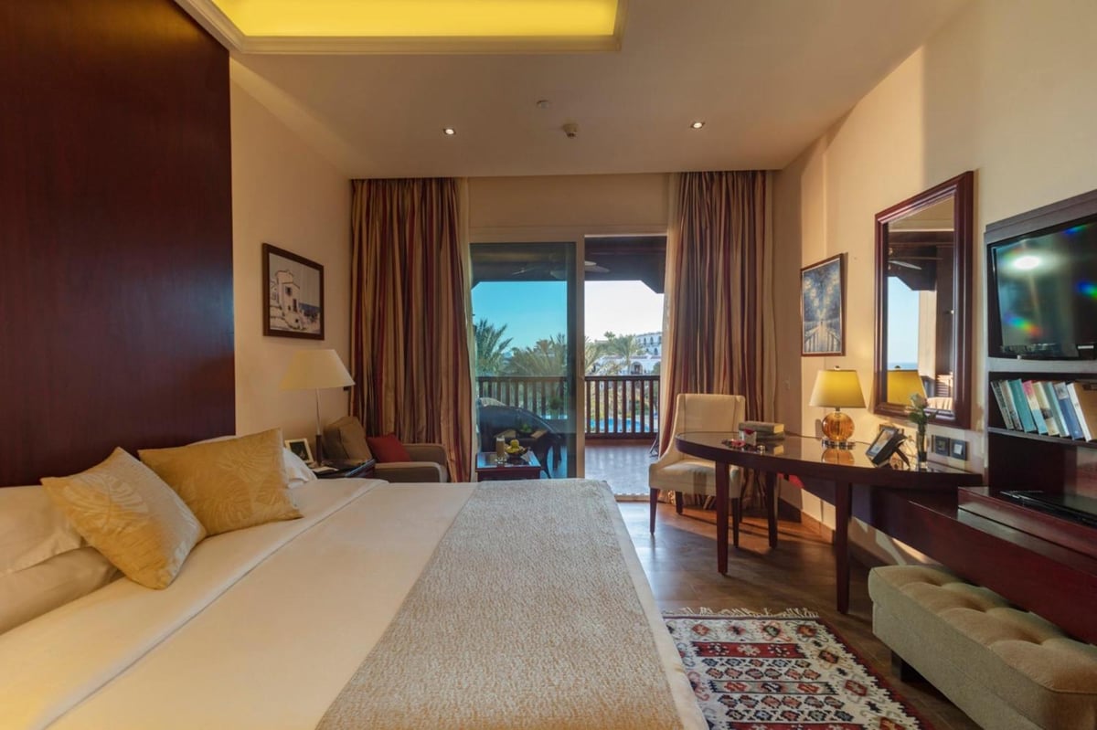 Royal Savoy Sharm El Sheikh guest room with a bed and sliding balcony doors.