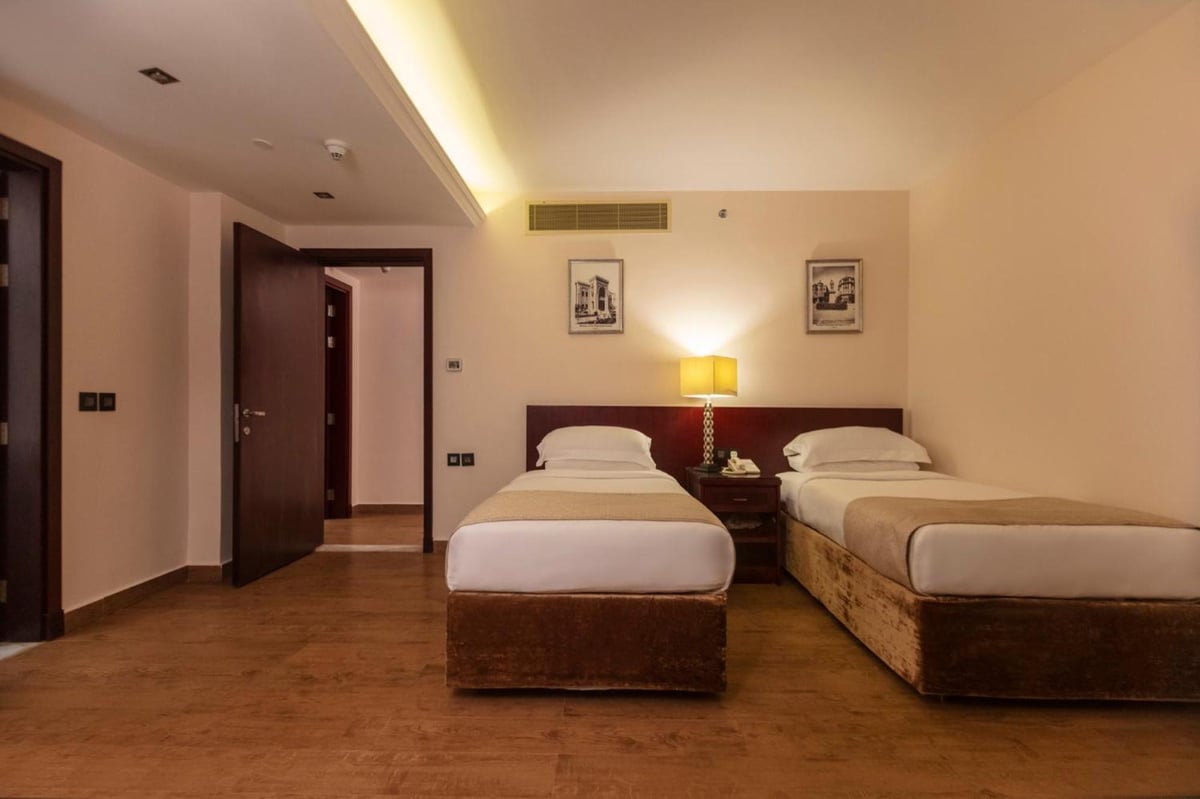 Royal Savoy Sharm El Sheikh twin bedroom with two single beds and wood flooring.