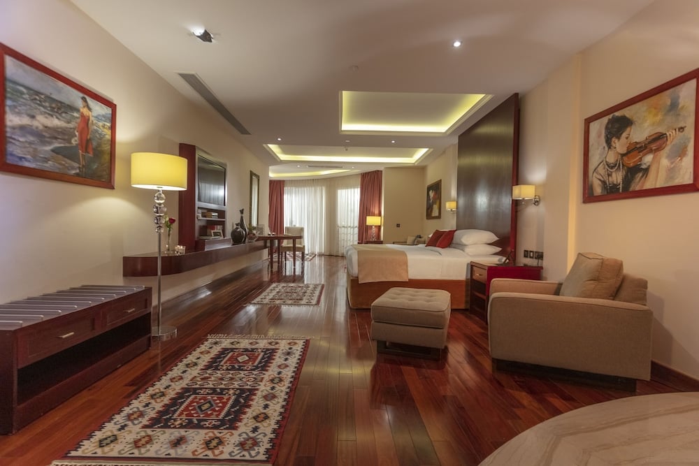 Royal Savoy Sharm El Sheikh guest room with a bed and seating area.