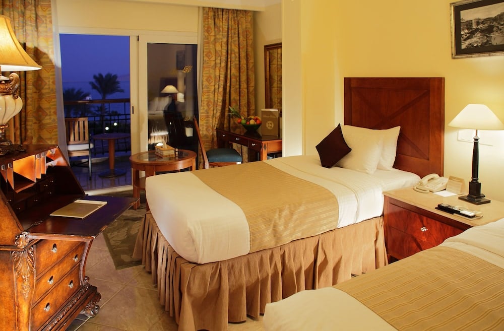 Royal Savoy Sharm El Sheikh guest room with twin beds and balcony doors.