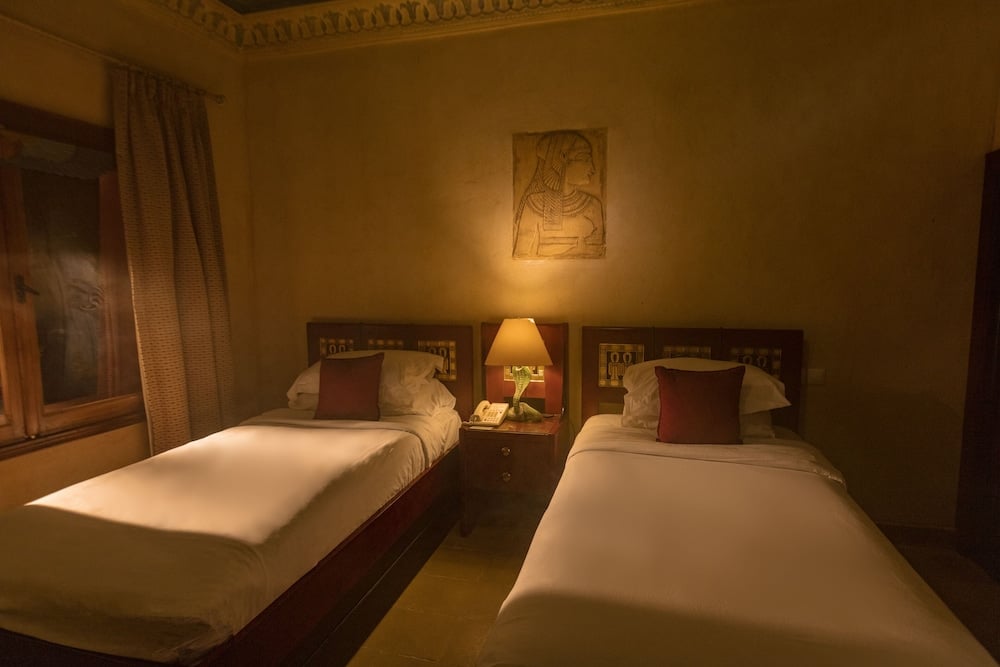 Royal Savoy Sharm El Sheikh twin bedroom with two single beds and a curtained window.