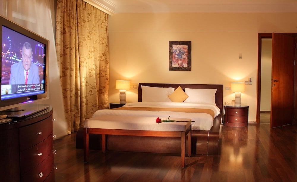 Royal Savoy Sharm El Sheikh guest bedroom with a large bed and polished wood floors.