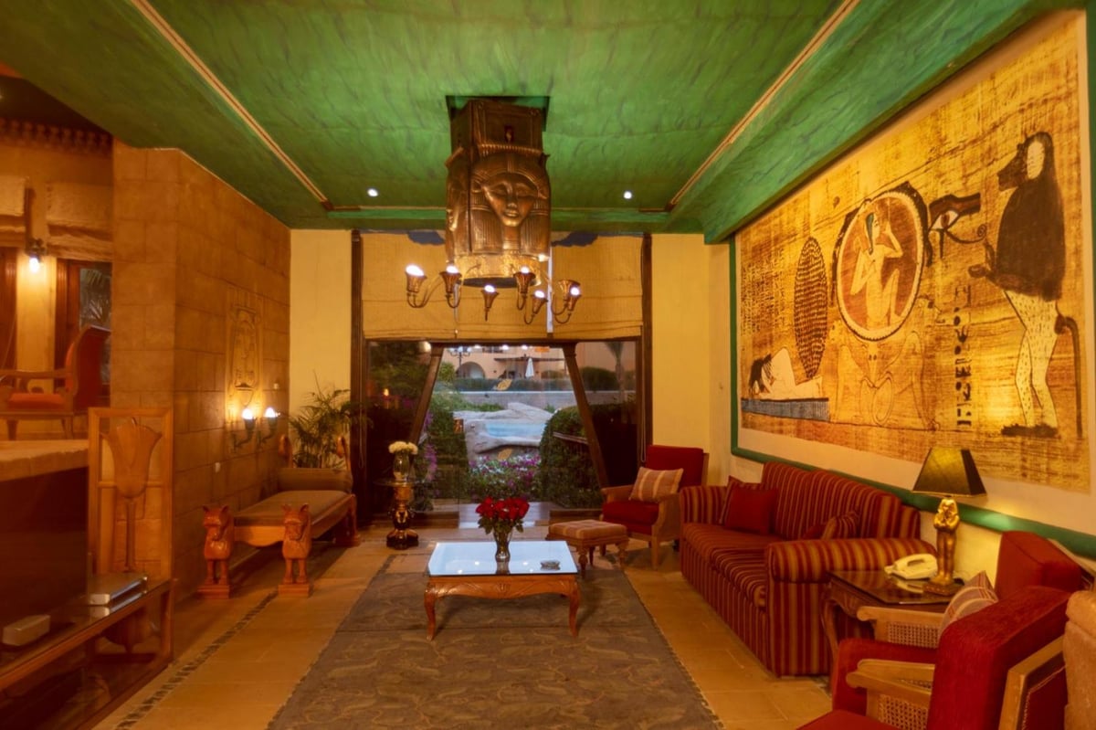 Royal Savoy Sharm El Sheikh lounge with a wall mural and striped sofas.