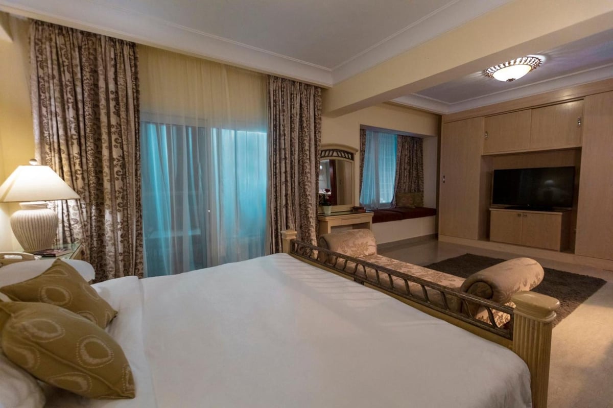 Royal Savoy Sharm El Sheikh bedroom with a large bed and patterned curtains.
