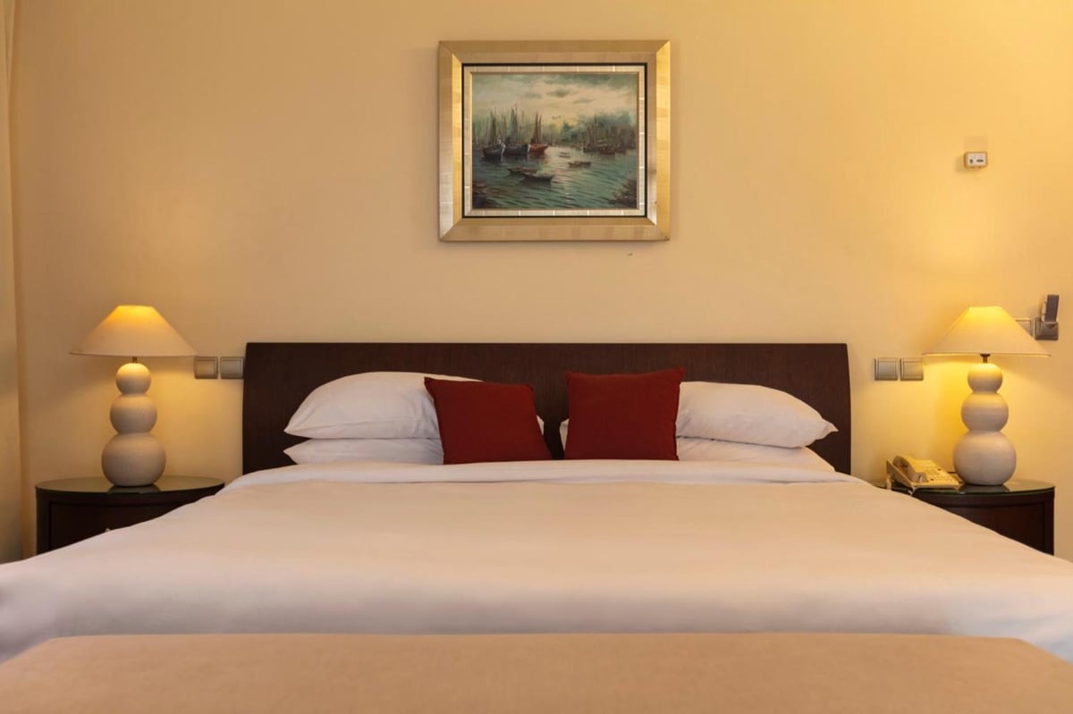 Royal Savoy Sharm El Sheikh bedroom with a wide bed and matching bedside lamps.