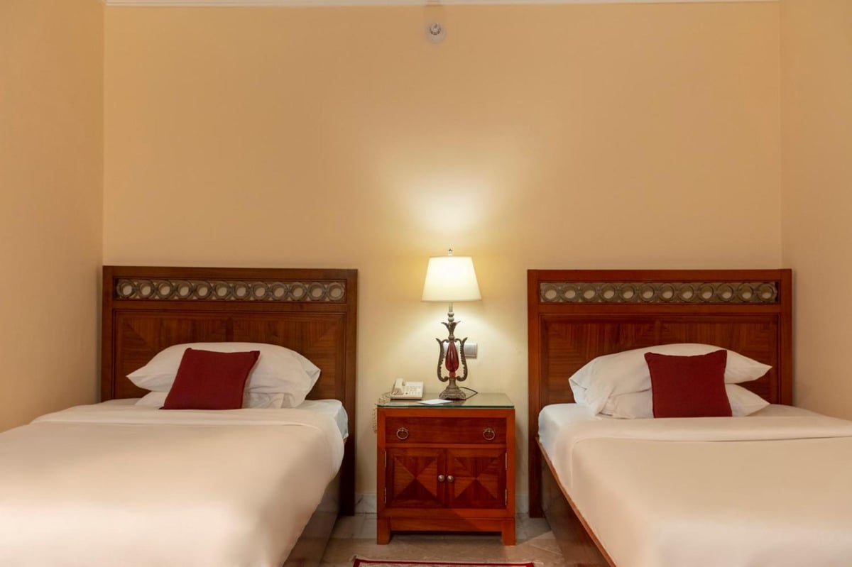 Royal Savoy Sharm El Sheikh guest room with two beds and wooden headboards.