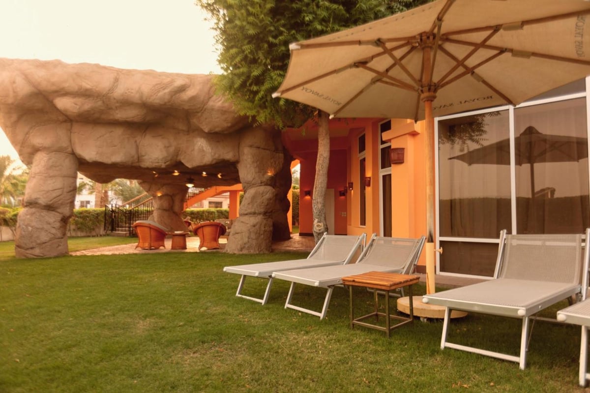 Royal Savoy Sharm El Sheikh patio with sun loungers and a rock canopy.