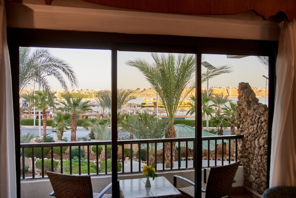 Turquoise Beach Hotel balcony with palm trees and landscaped grounds.