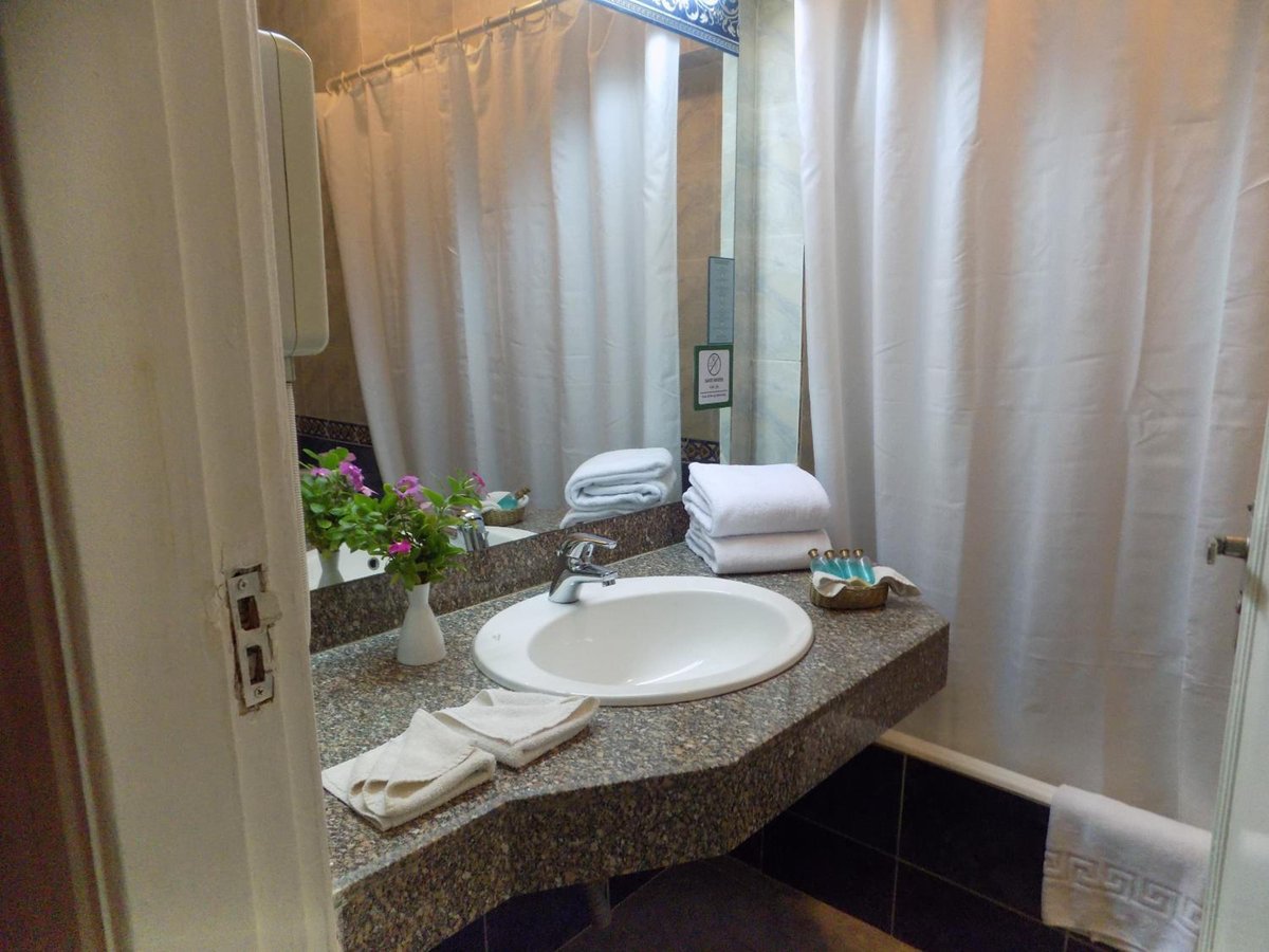 Turquoise Beach Hotel bathroom vanity with a sink and large mirror.