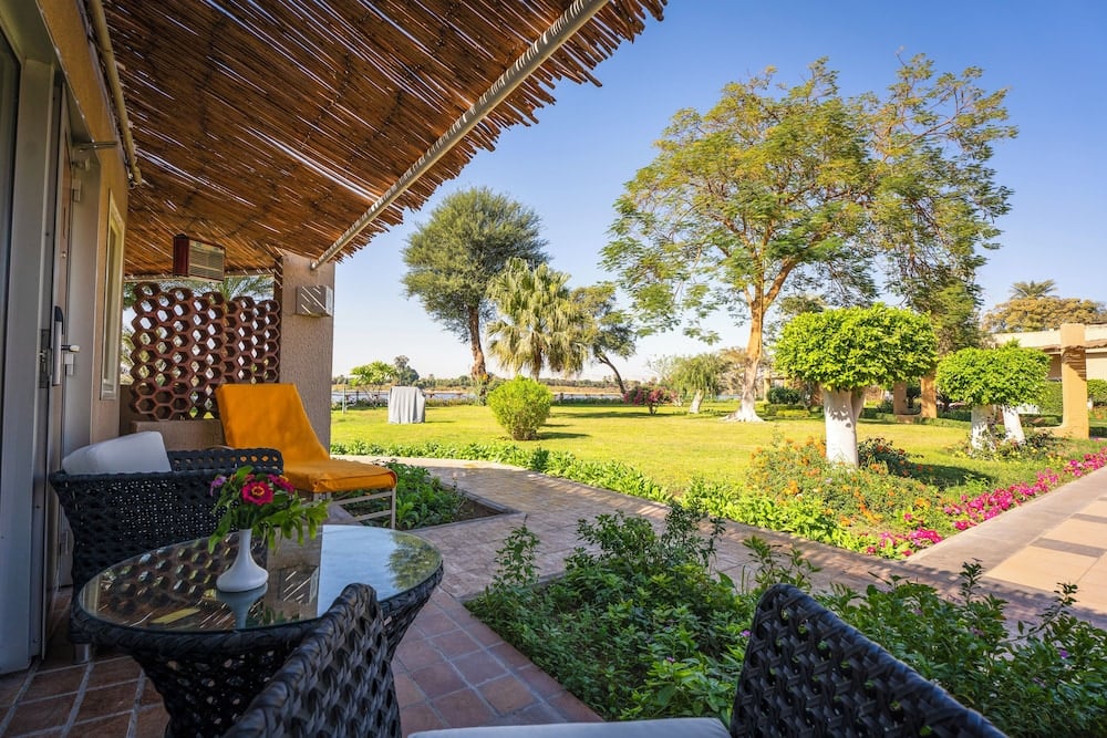 Jolie Ville Hotel & Spa Kings Island Luxor patio with shaded seating and a landscaped garden.