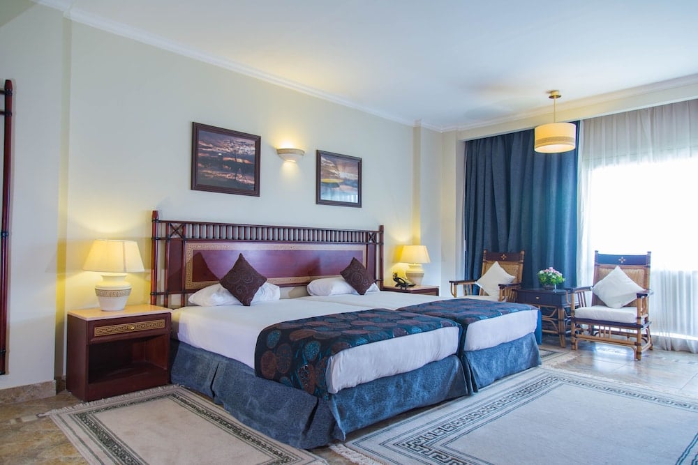 Jolie Ville Hotel & Spa Kings Island Luxor guest room with twin beds and armchairs.