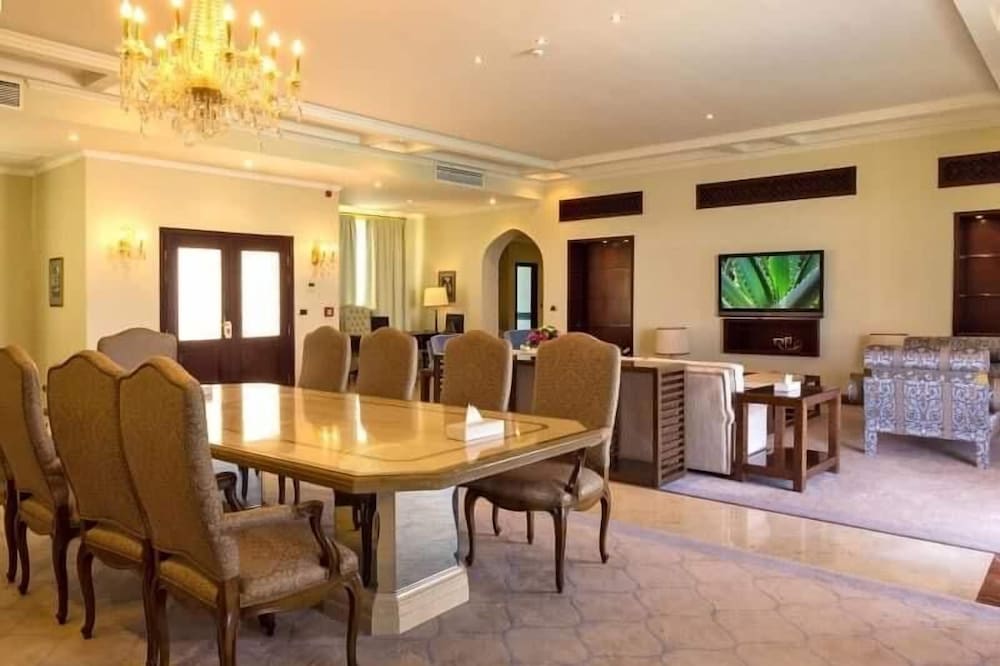 Jolie Ville Hotel & Spa Kings Island Luxor dining room with a large table and upholstered chairs.