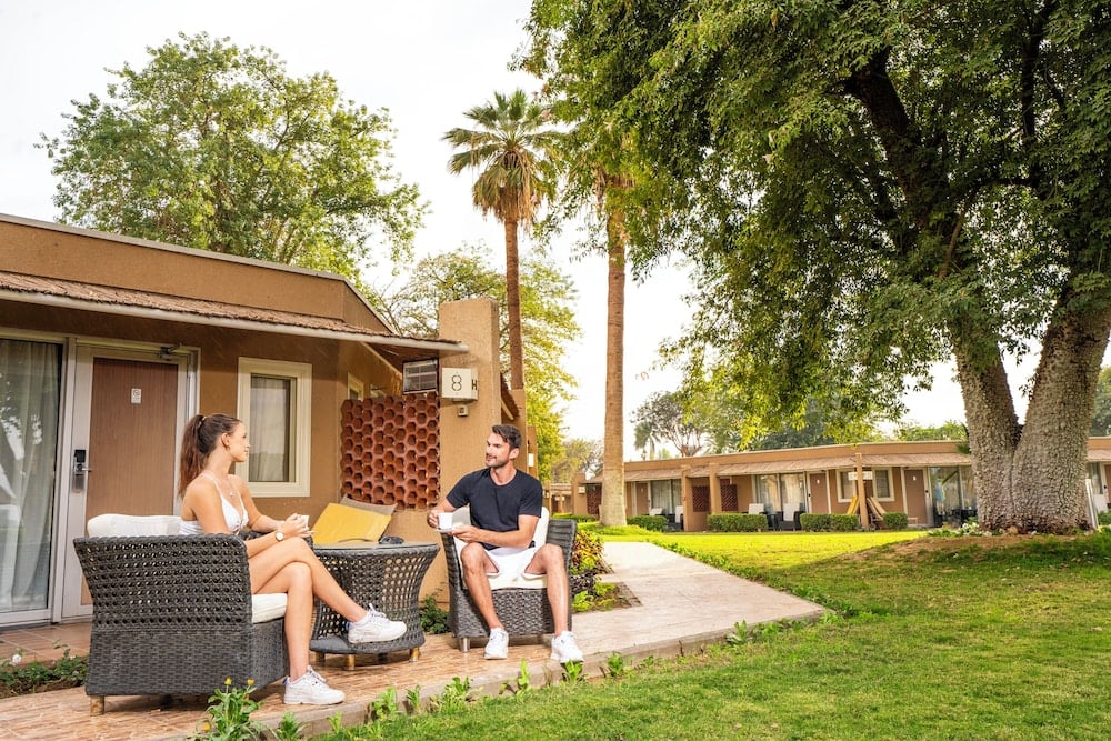 Jolie Ville Hotel & Spa Kings Island Luxor patio with wicker seating and a lawn.