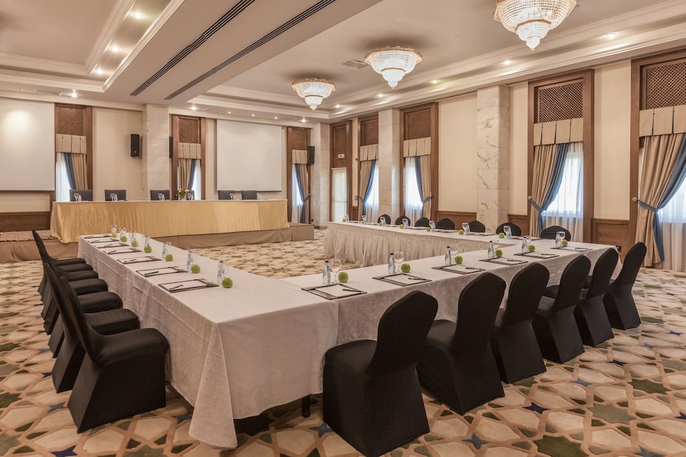 Jolie Ville Hotel & Spa Kings Island Luxor meeting room with U-shaped tables and chandeliers.