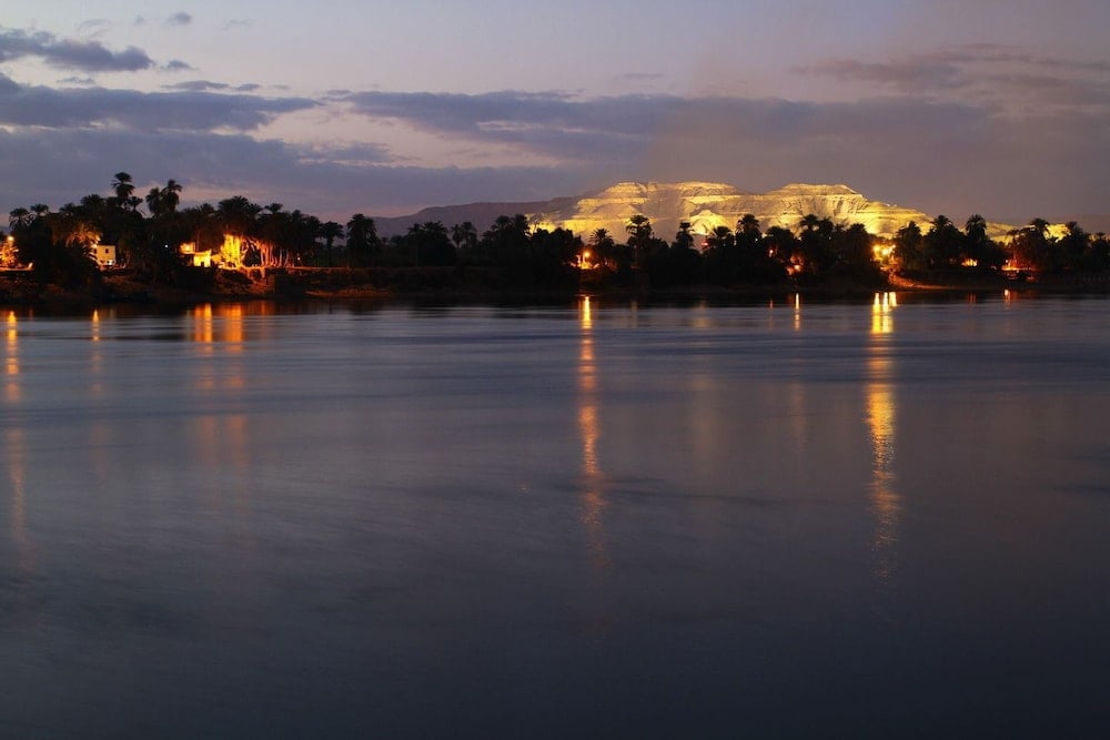 Jolie Ville Hotel & Spa Kings Island Luxor river view with calm water and lights along the far bank.