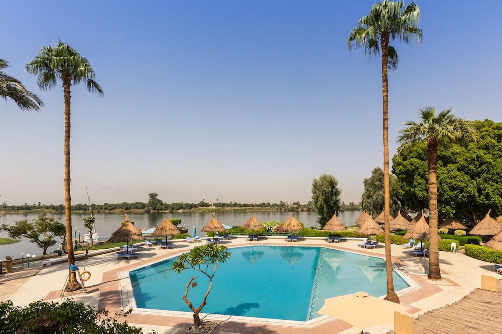Jolie Ville Hotel & Spa Kings Island Luxor pool with turquoise water and palm trees.