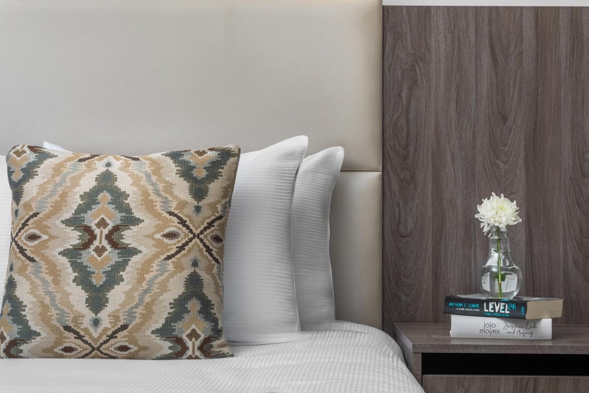 Albatros Makadi Resort bedroom with a patterned cushion and bedside table.